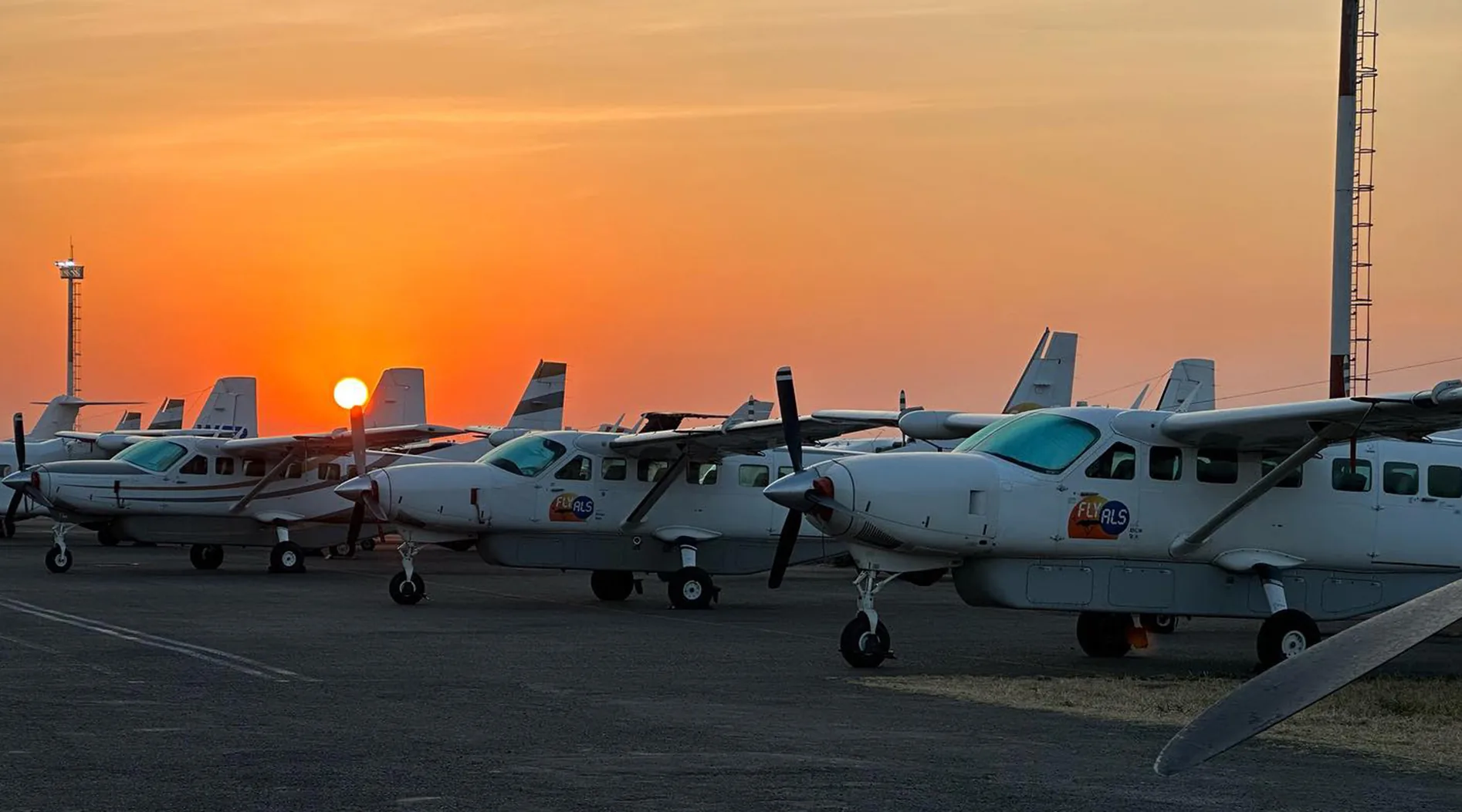 Fly ALS Grand Caravans lined up on the apron at sunset