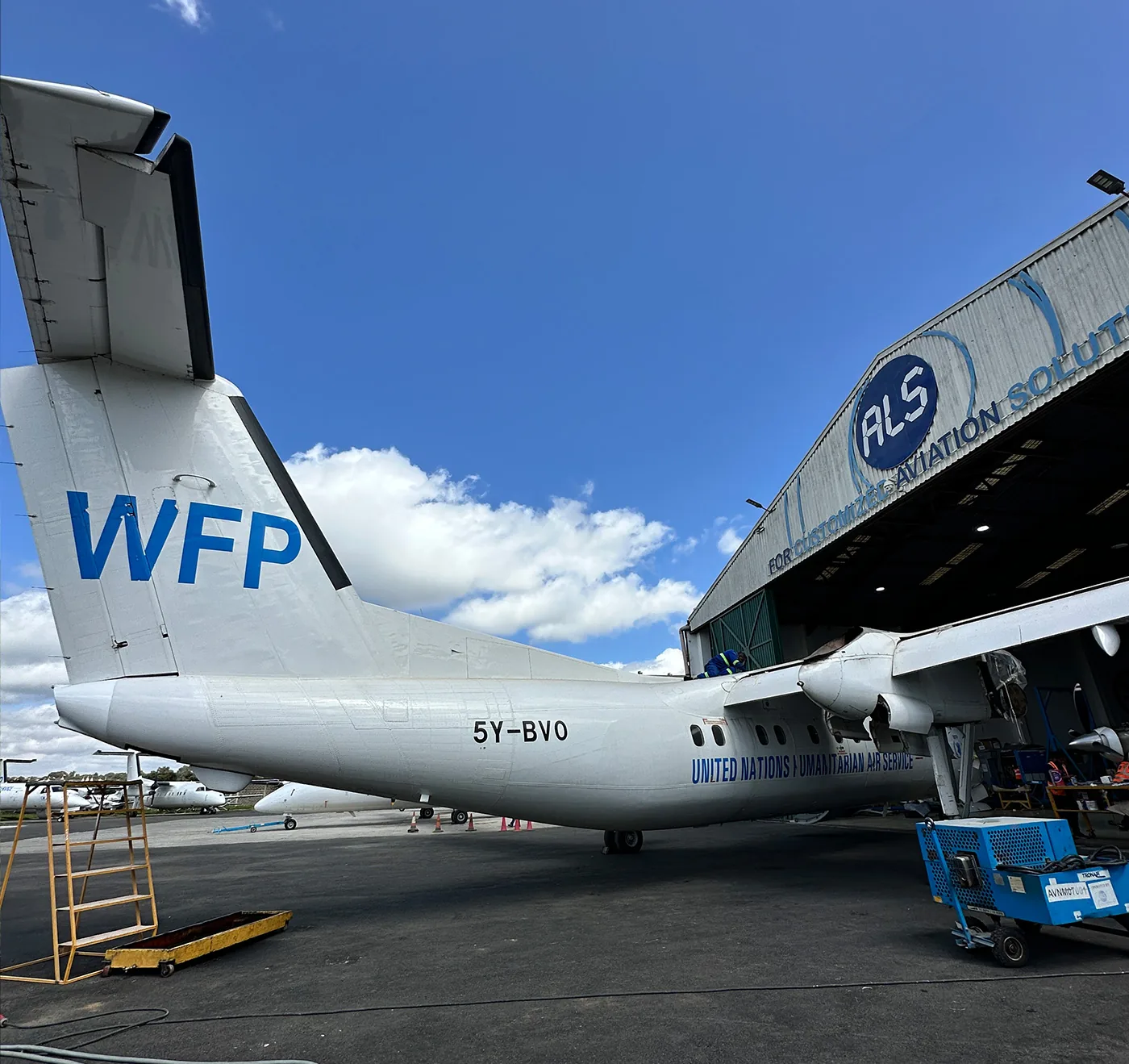 The tail of a Dash 8 in UN World Food Programme colours outside the ALS hangar